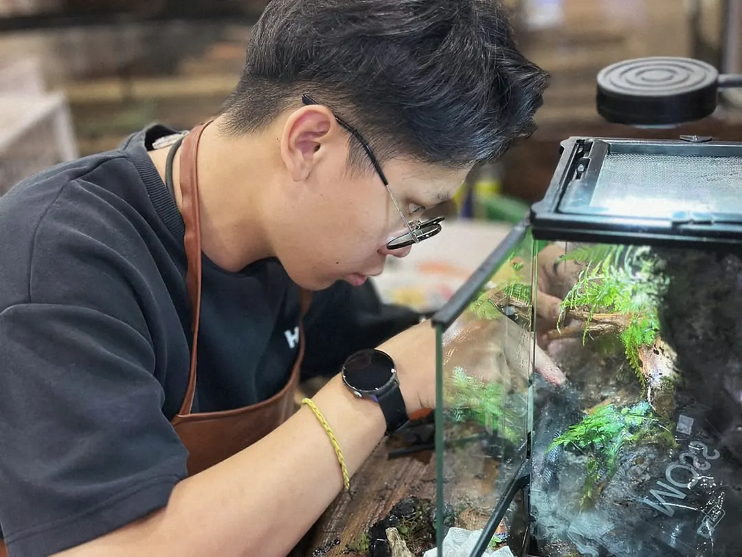 A maker planting a closed terrarium at the bench