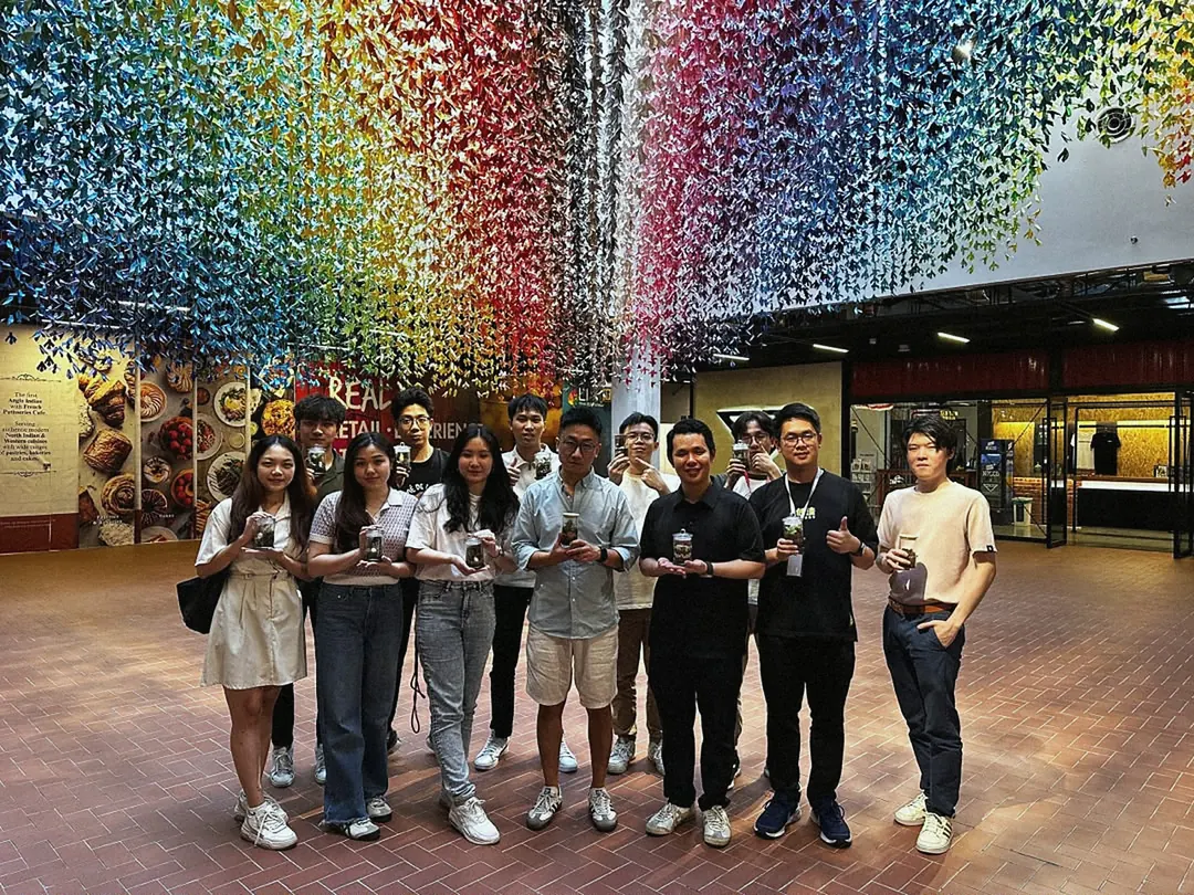 A group photo under a ceiling of hanging colour
