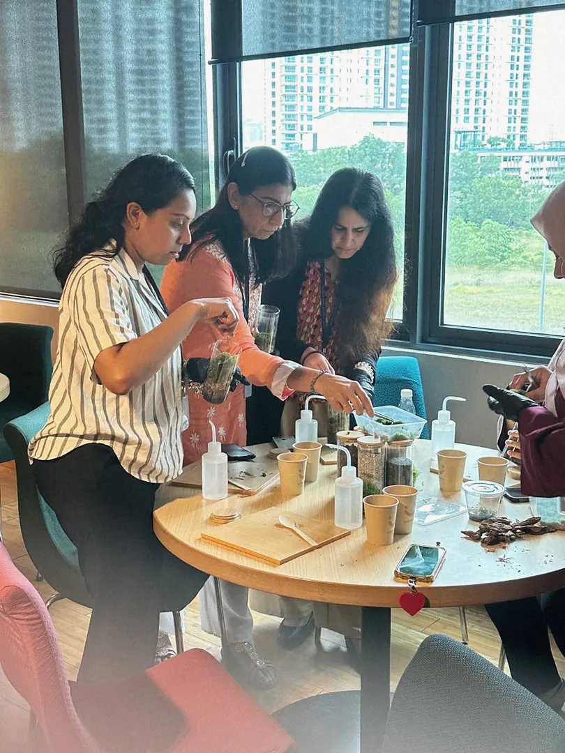 Guests building terrariums around a workshop table