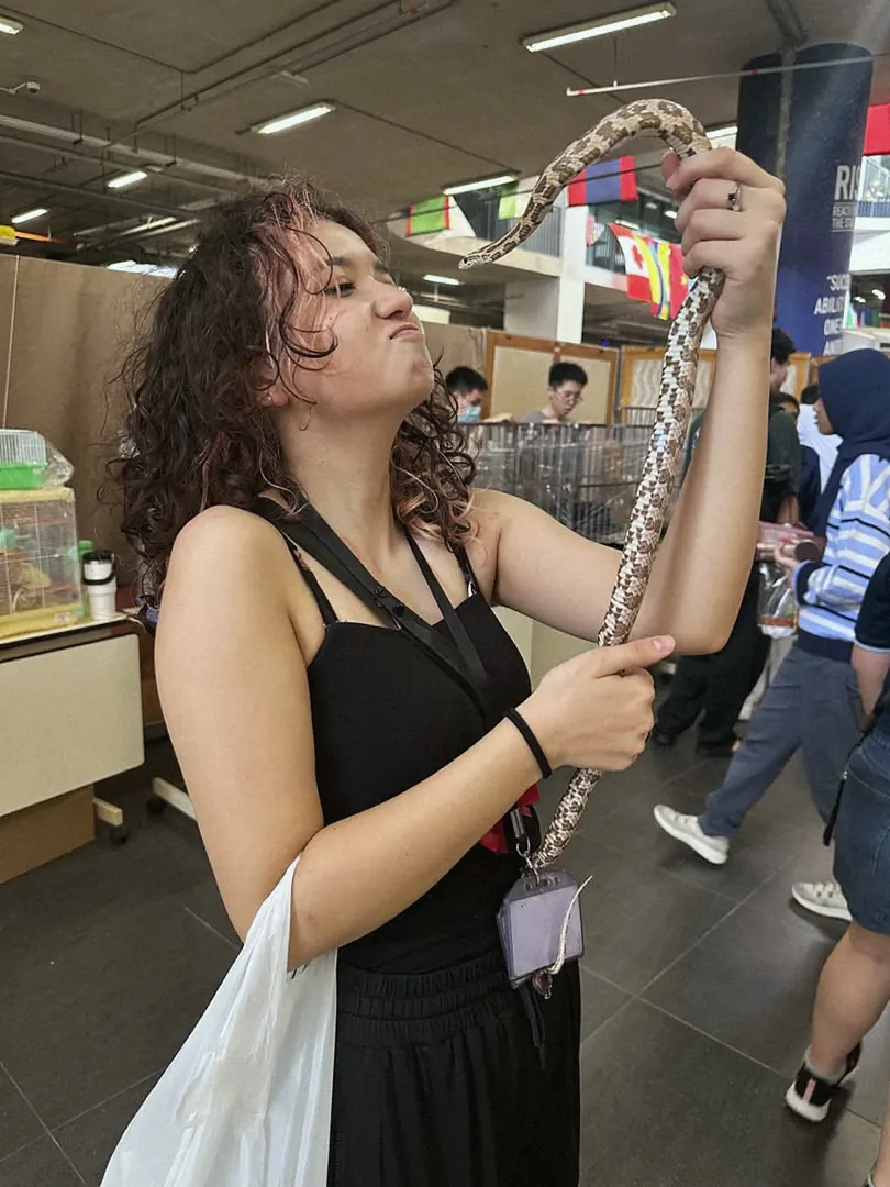 A visitor holding a snake at one of our events